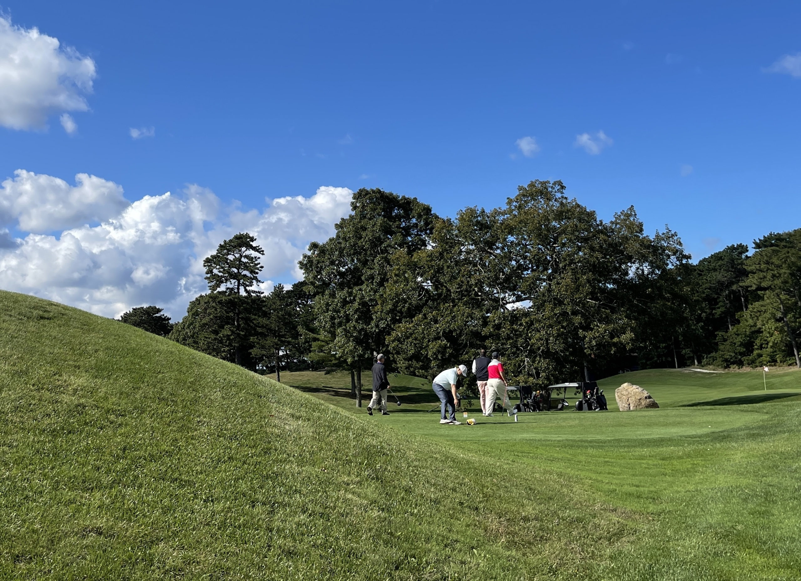Several people golfing under blue sky in Falmouth